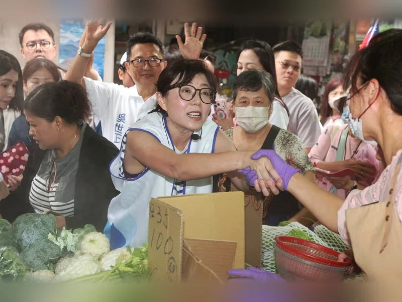 石舫亘穿著蔣萬安競選背心，在內湖湖光市場和攤商握手