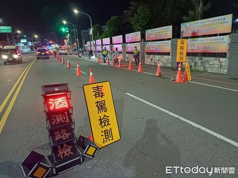 夜間道路上擺著「毒駕檢測」黃色告示牌與「酒測路檢」燈號，警察在路邊攔檢機車