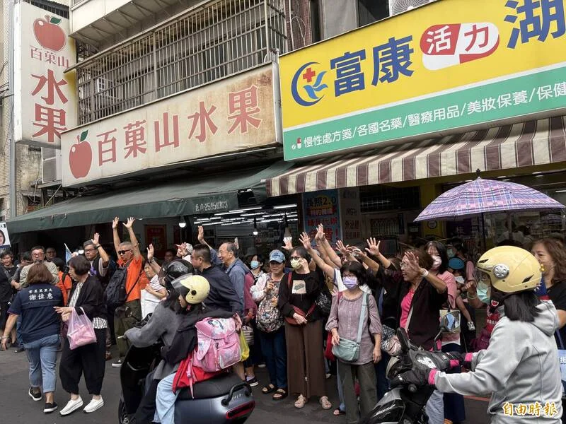 湖光市場外的支持者舉手比出數字 5