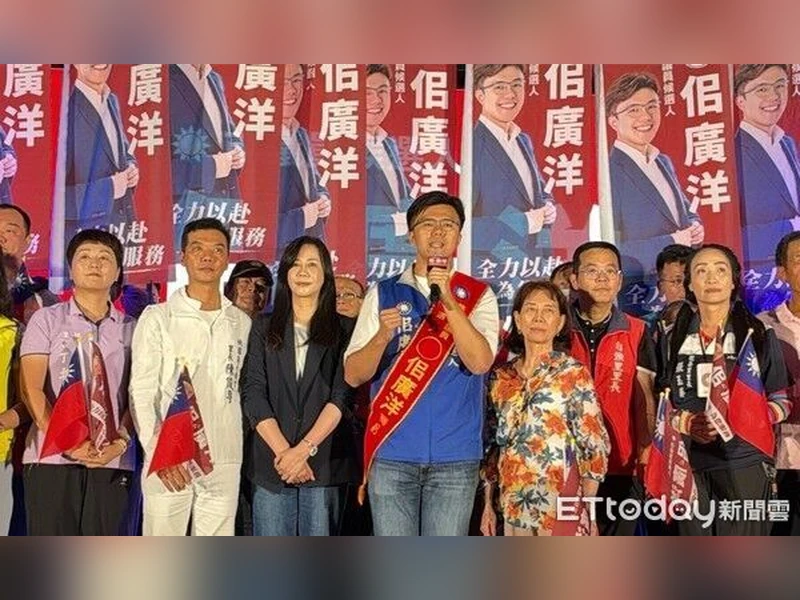 佀廣洋在競選總部成立大會上拿麥克風致詞，身旁站著支持者