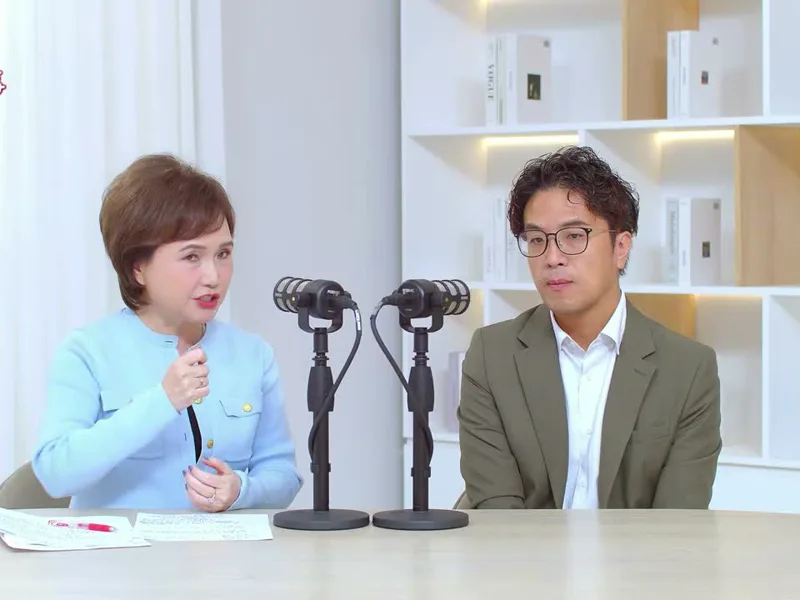 沈春華用台語提問時比著手勢，沈伯洋坐在一旁聽