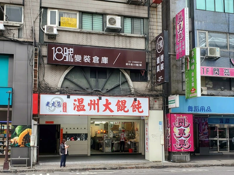 街邊大樓 2 樓掛著「18號變裝倉庫」招牌，1 樓是溫州大餛飩
