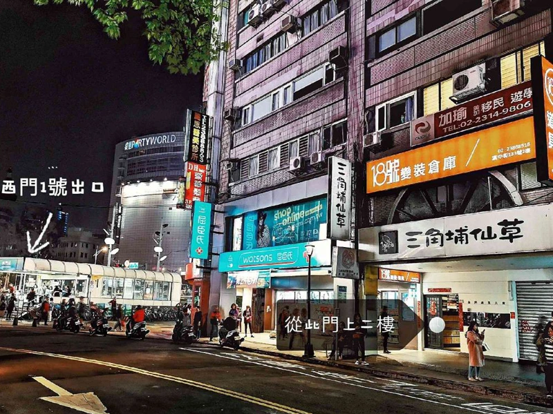 夜晚的西門町街景，標示從西門站 1 號出口走到店門口的方向