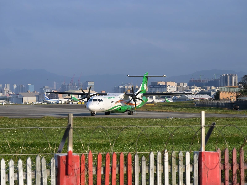 立榮航空 ATR 72-600 螺旋槳客機在松山機場跑道旁滑行，後方是台北市區