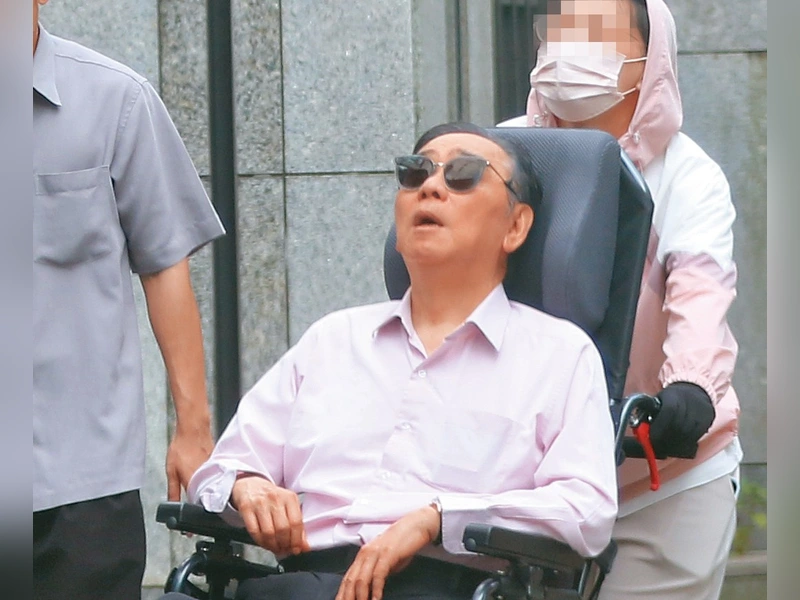 王文洋戴墨鏡坐輪椅抬頭曬太陽