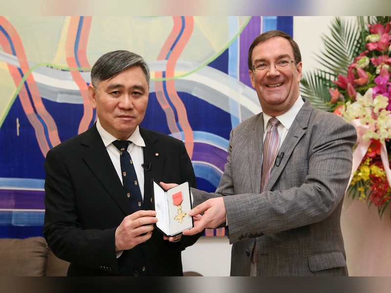 王文洋手拿大英帝國官佐勳章和英國代表合照